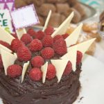 Cake decorated with white chocolate shards and raspberries