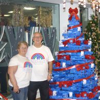 Mary and her husband from Francis House stood with the Midshire donation to the Festival of Christmas Trees