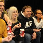 Group shot of NK theatre staff watching a play with Midshire donated popcorn